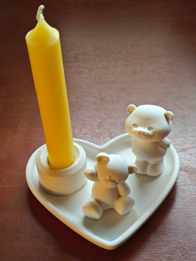 Teddypaar mit Kerze auf Herzschale